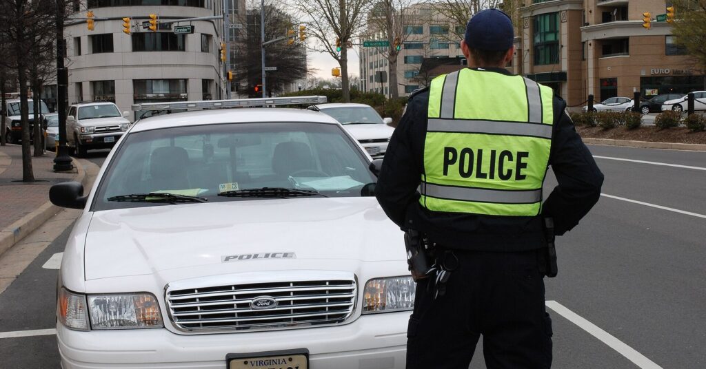 Police officer in a POLICE vest from behind